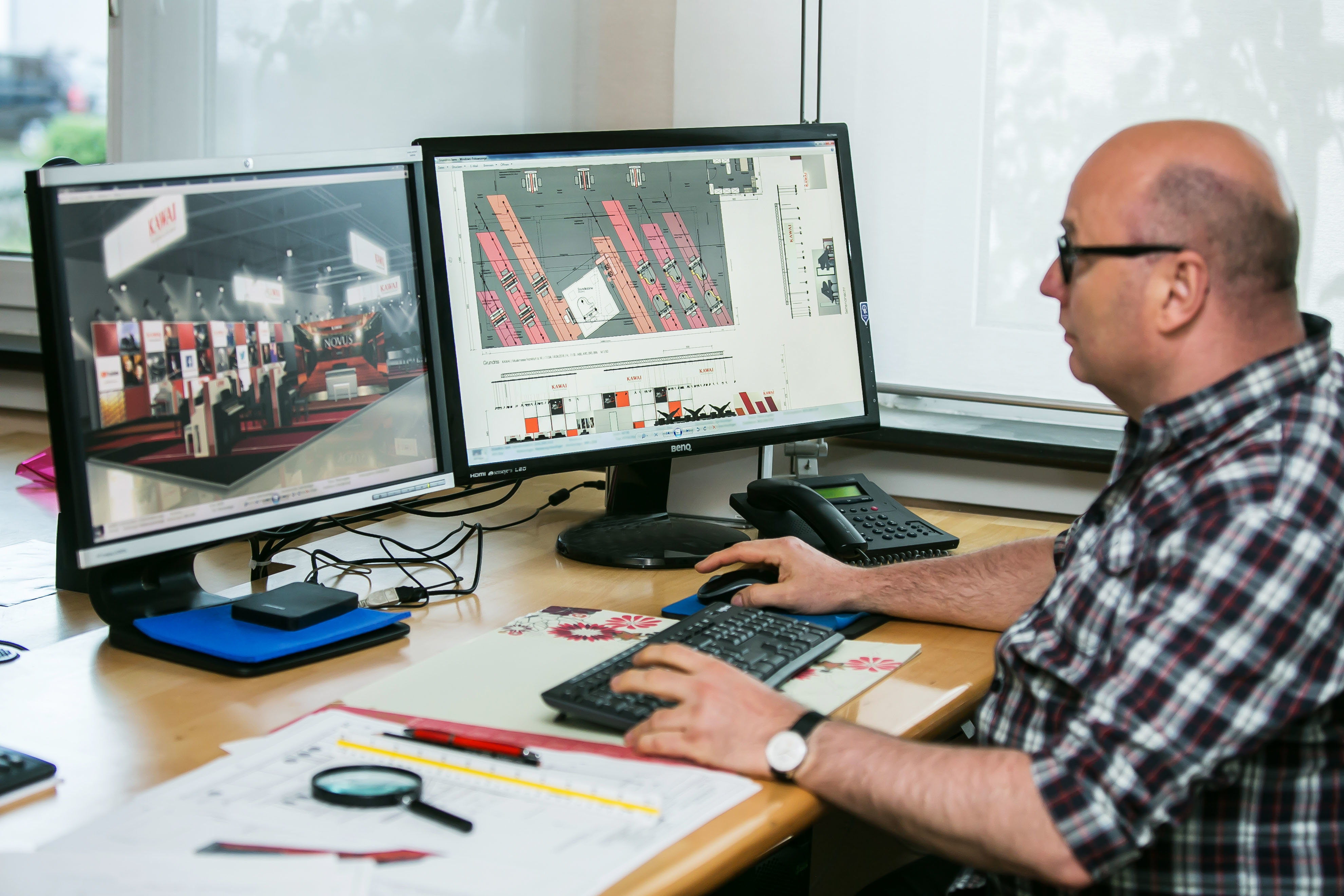 Mitarbeiter konzipiert an einem Monitor mit Spezialsoftware einen Messtand in 3D-Optik